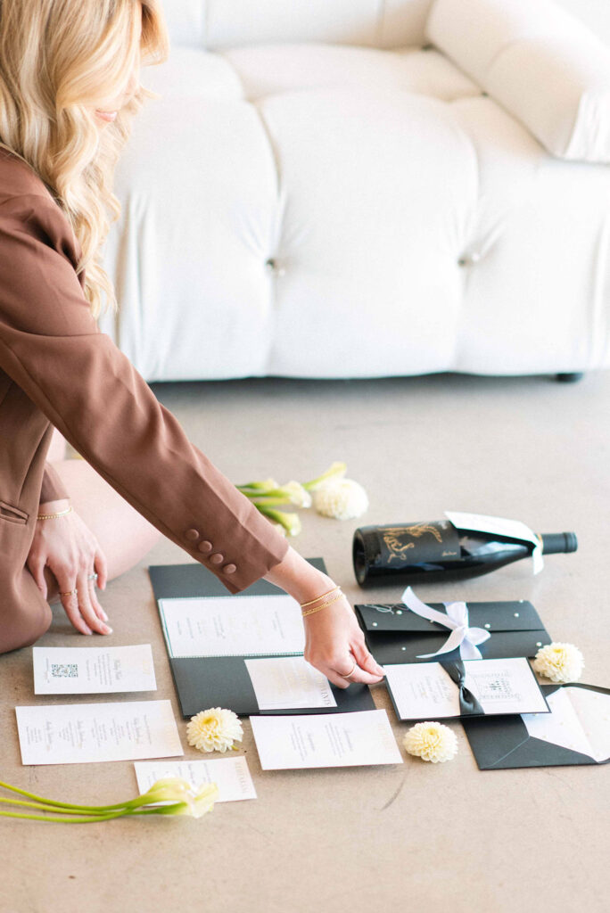 wedding stationer placing classic wedding invitations, black and white, foil, letterpress, in flatlay pose